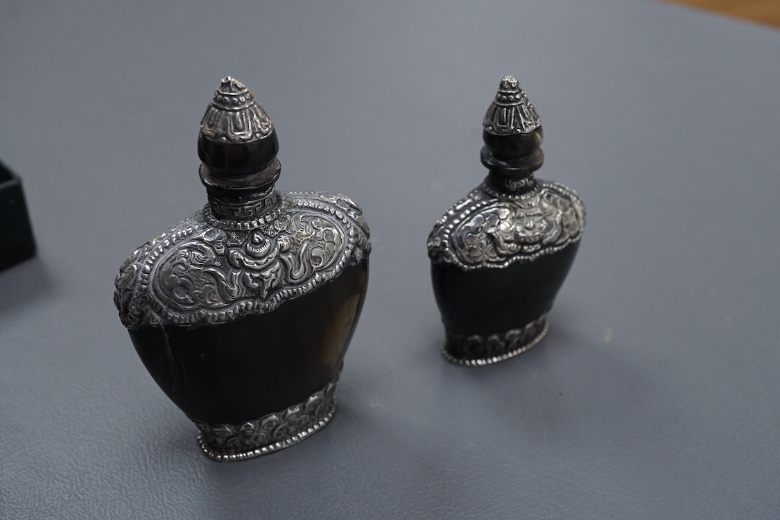 Two late 19th/early 20th century Nepalese embossed white metal mounted horn snuff bottles, largest 87mm.